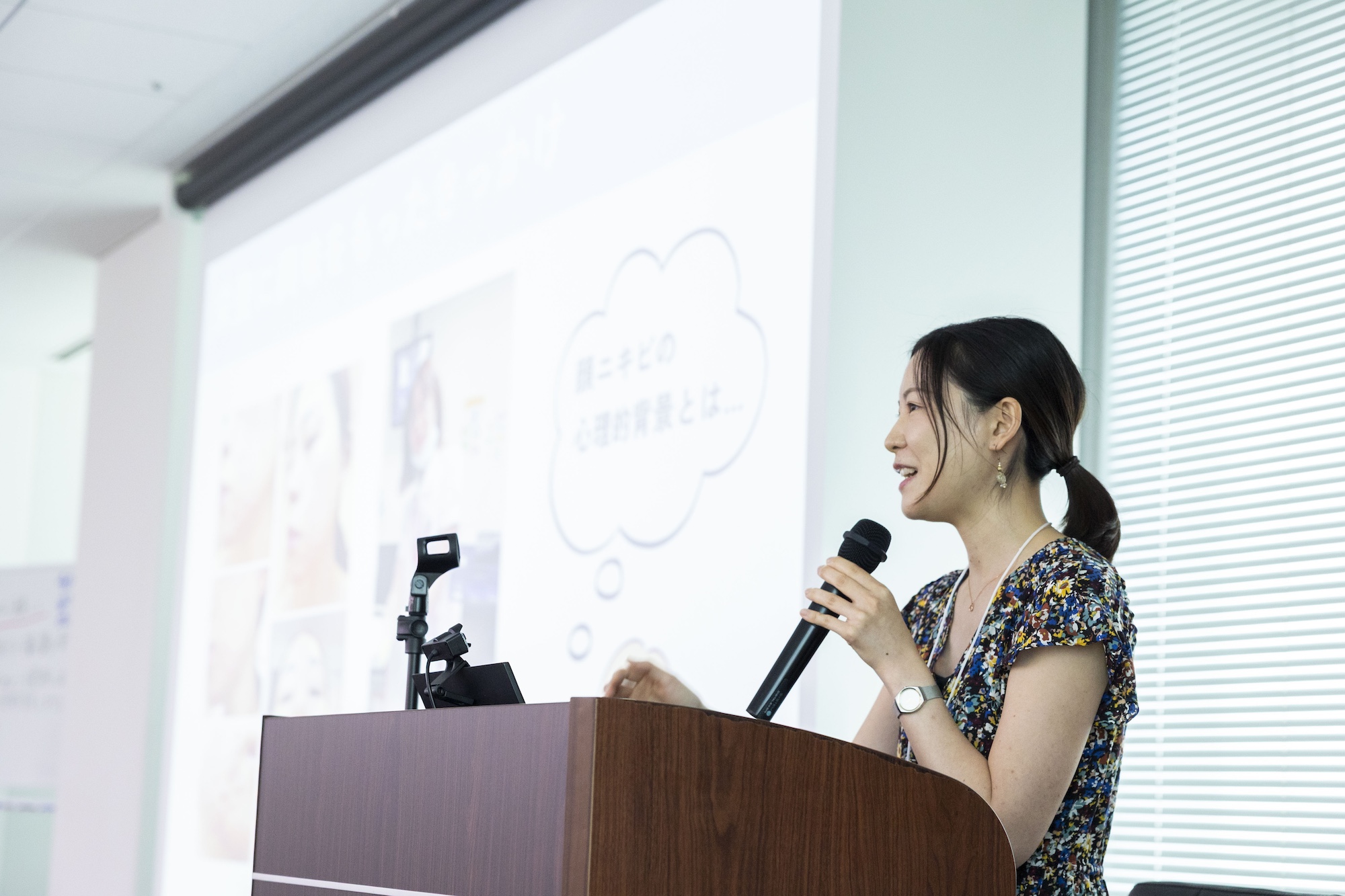 登壇者がマイクを持って症例発表をしている様子