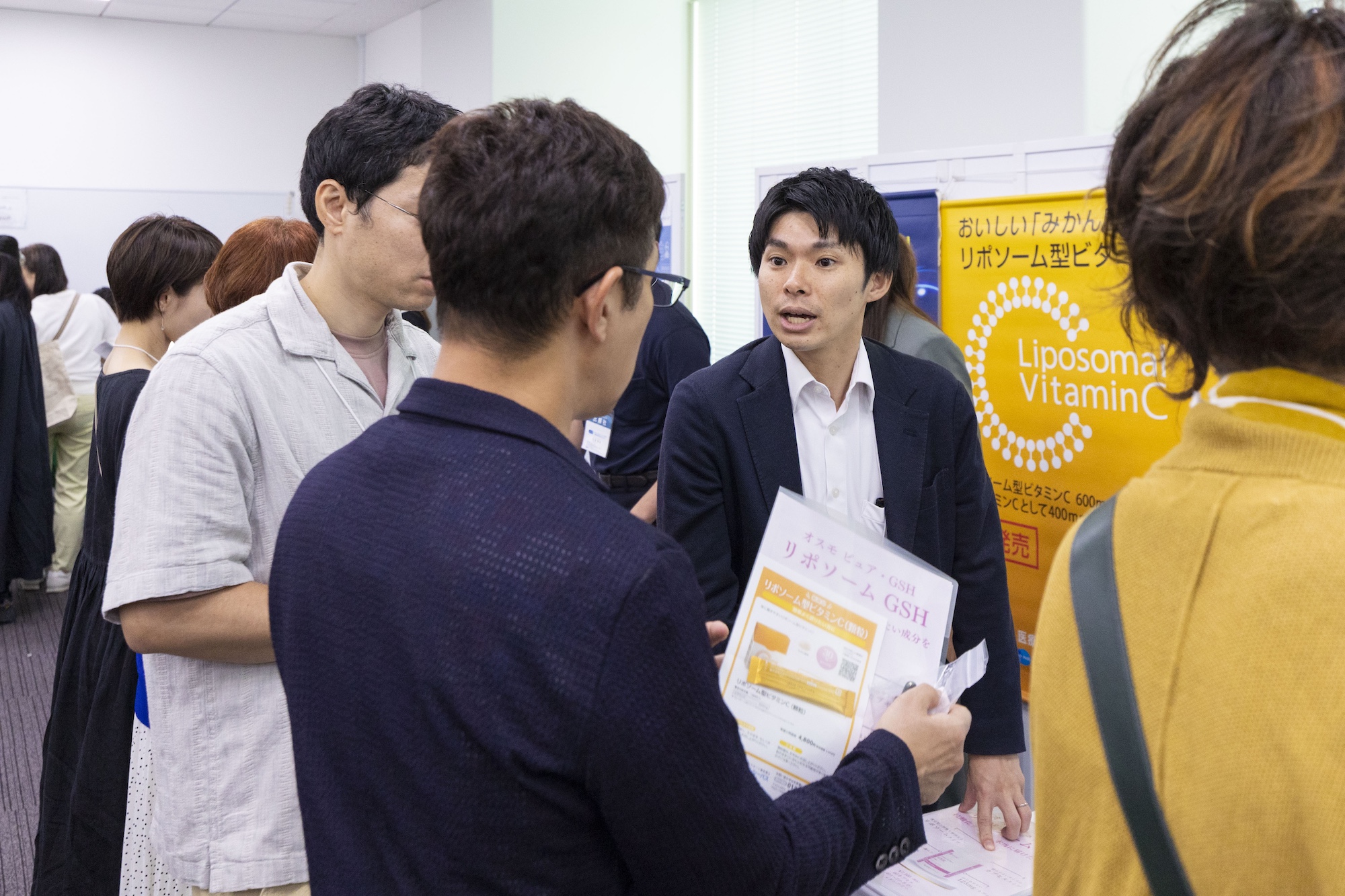 協賛企業ブースで参加者が説明を聞いている様子